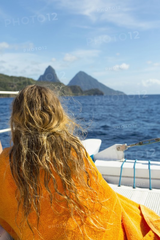 Caucasian girl sitting on boat wrapped in a towel