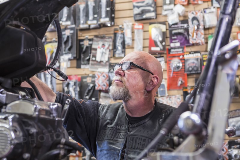 Caucasian man repairing motorcycle