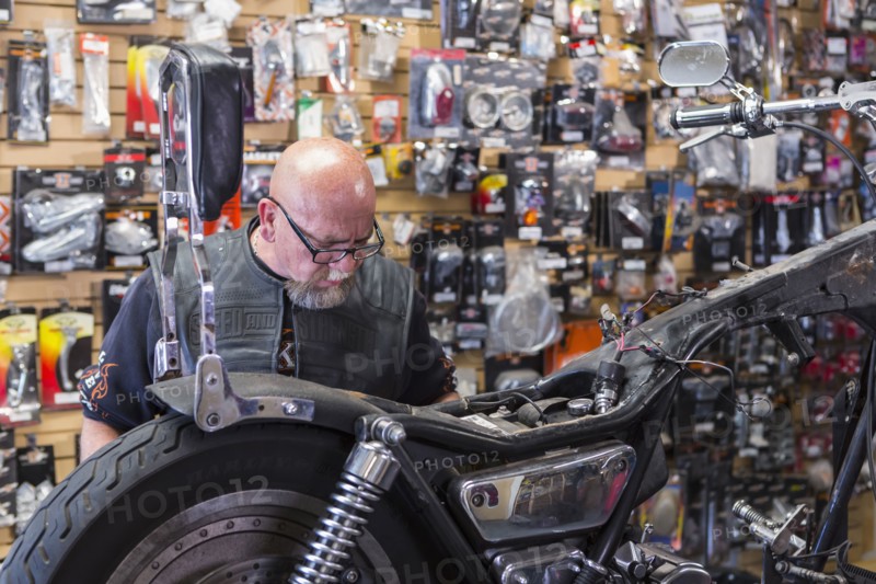 Caucasian man repairing motorcycle