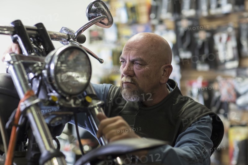 Caucasian man repairing motorcycle