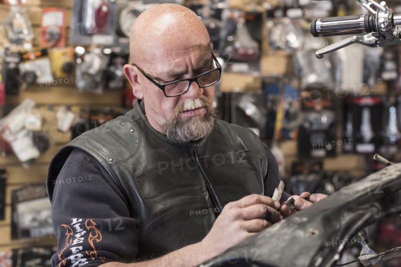 Caucasian man repairing motorcycle