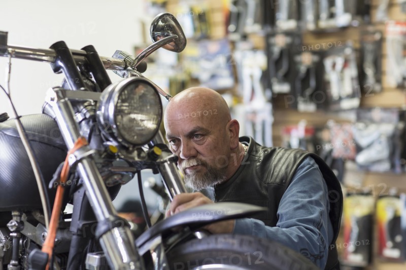 Caucasian man repairing motorcycle