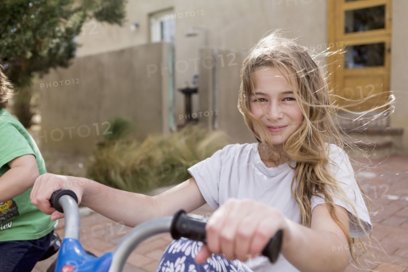 Wind blowing hair of Caucasian girl on bicycle