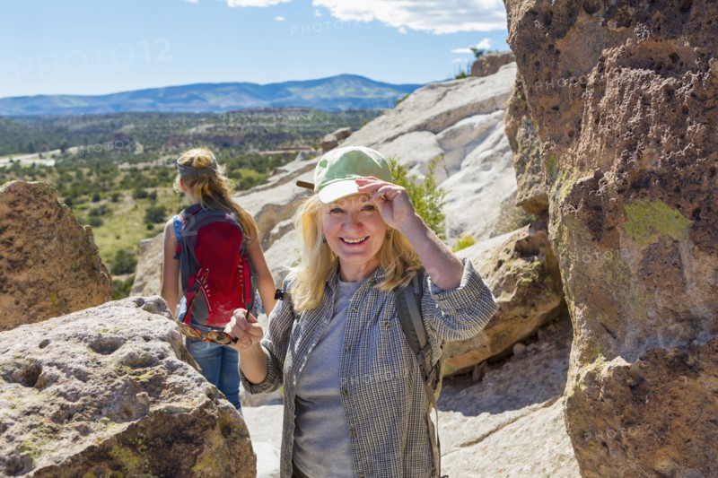 Caucasian grandmother hiking with granddaughter near rocks