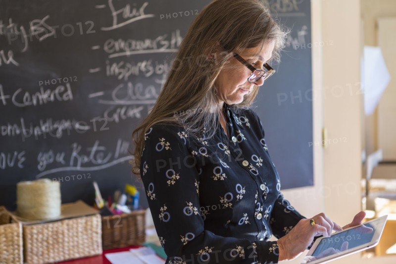 Caucasian teacher using digital tablet in classroom