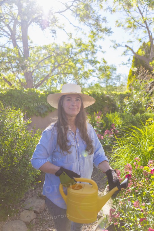 Older Caucasian woman holding watering can
