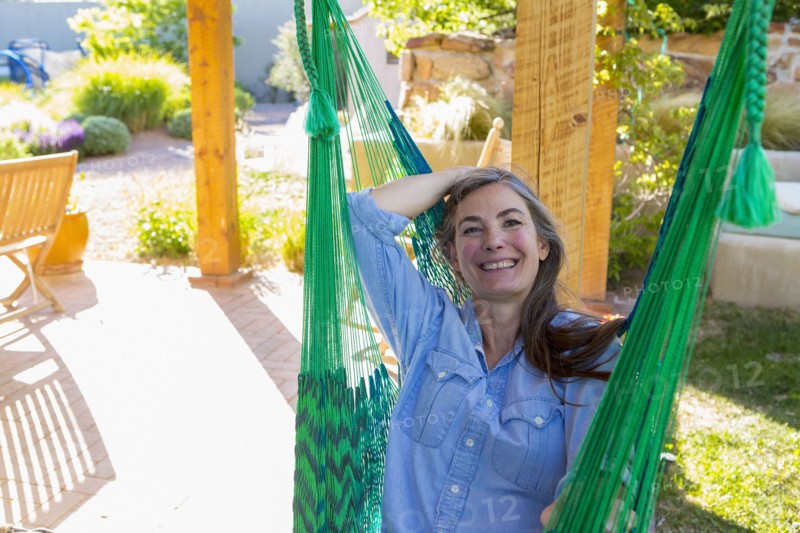 Older Caucasian woman laying in green hammock