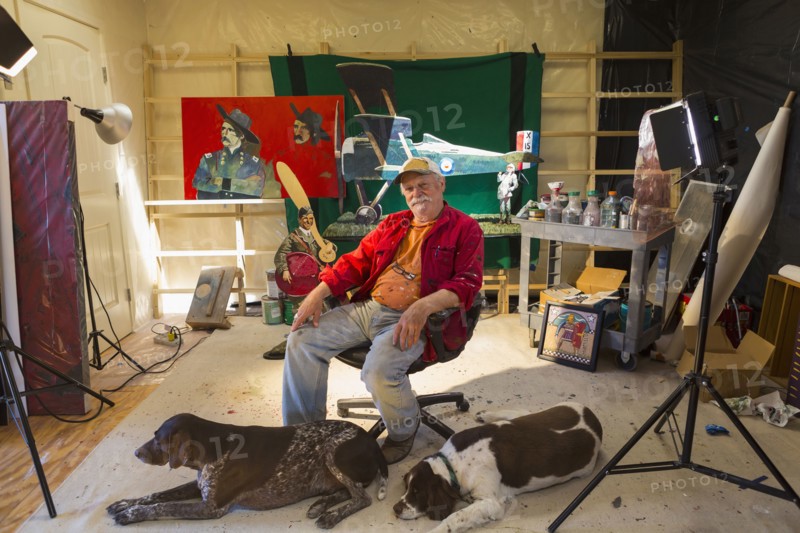 Portrait of older Caucasian man in workshop with dogs