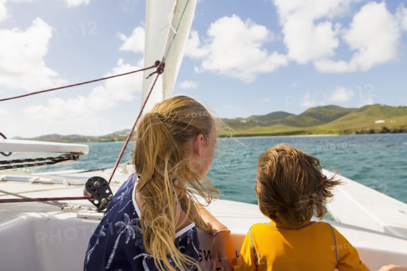 Wind blowing hair of Caucasian brother and sister in sailboat