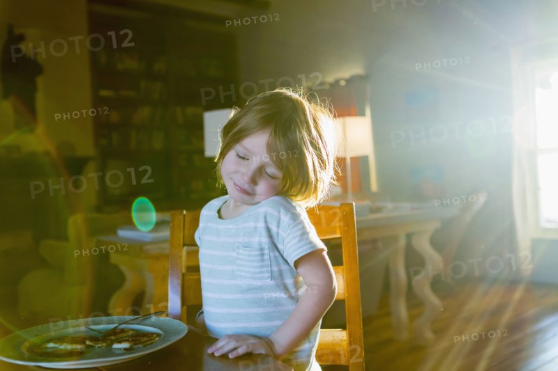Sunshine on Caucasian boy eating food at table
