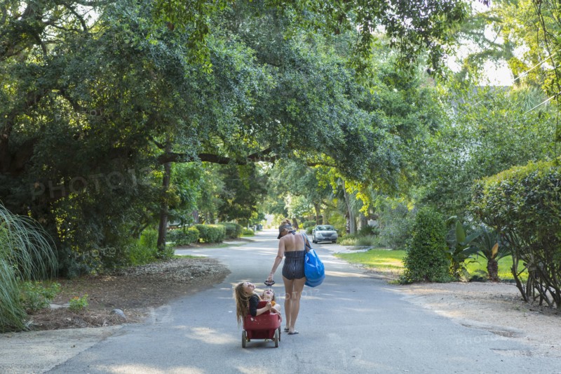 Caucasian mother pulling son and daughter in wagon
