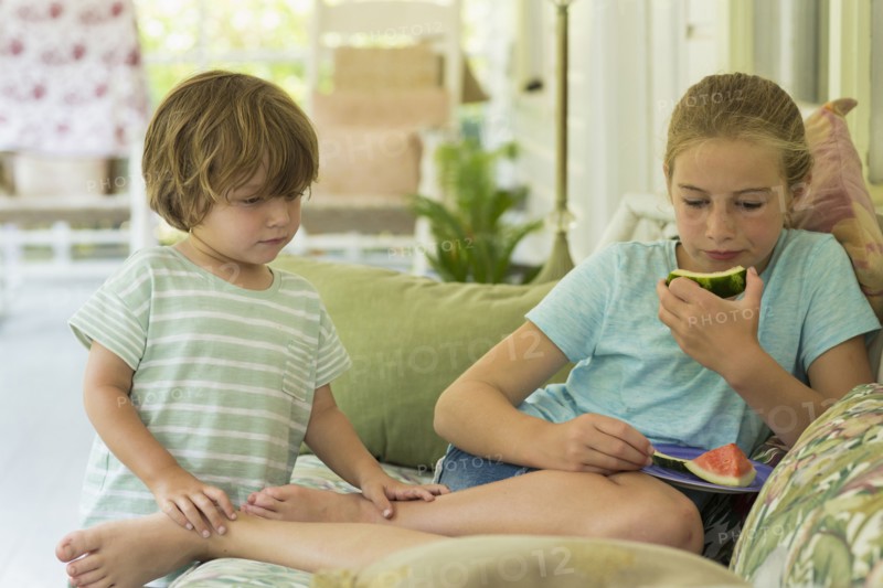 Caucasian brother and sister watching digital tablet on sofa