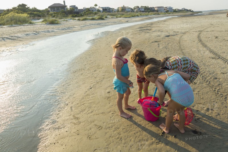 Caucasian boy and girls playing with pail on beach