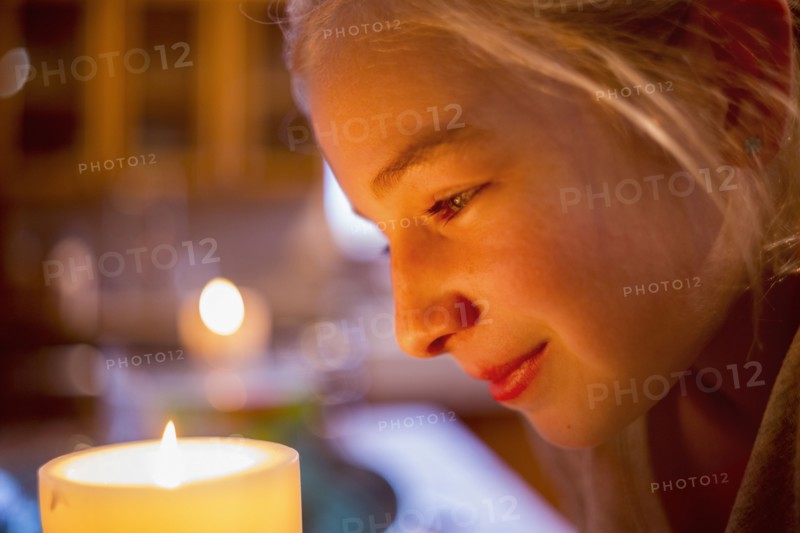 Smiling Caucasian girl watching candle