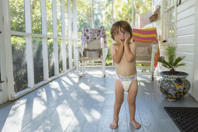 Caucasian boy on the porch wearing a diaper