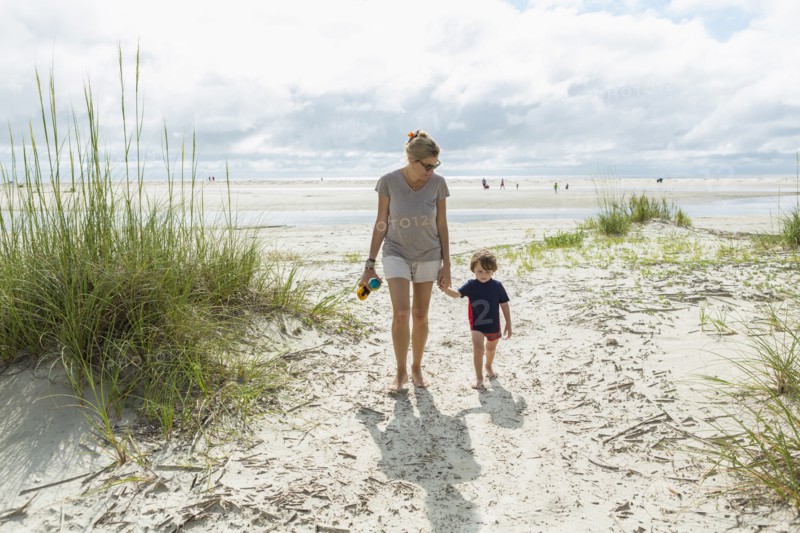 Caucasian mother and son walking on beach