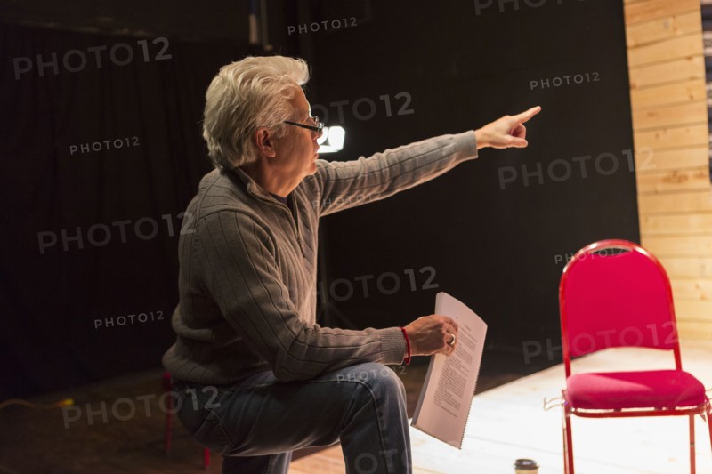 Hispanic man holding script pointing in theater