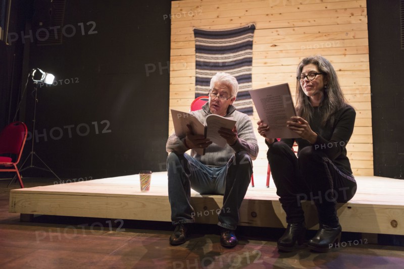 Hispanic man and woman reading scripts on theater stage