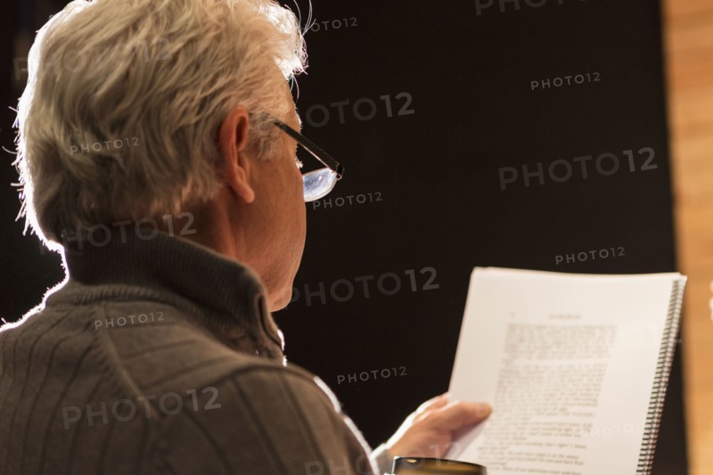 Hispanic man reading script in theater