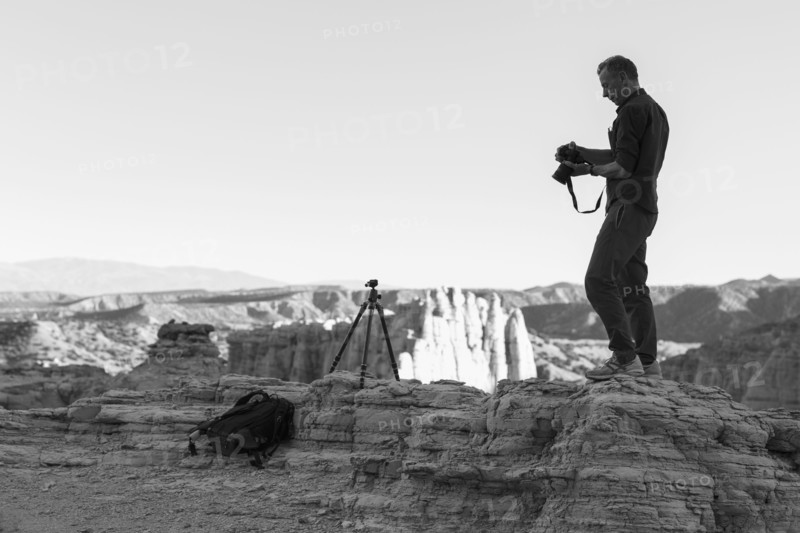 Caucasian photographer with tripod in desert