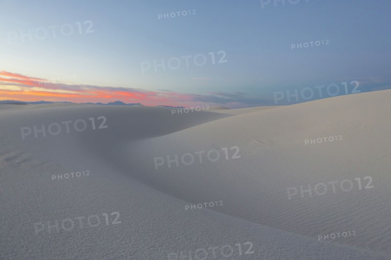 Sand dunes in desert at sunset