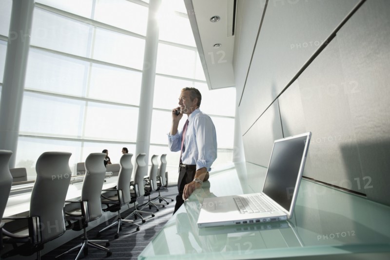 Businessman talking on cell phone in conference room