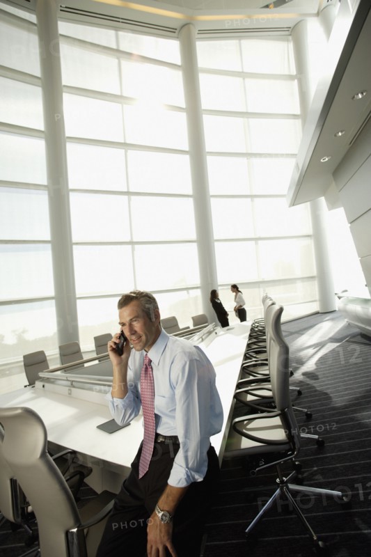 Businessman talking on cell phone in conference room