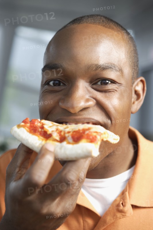 Close up of African man eating pizza