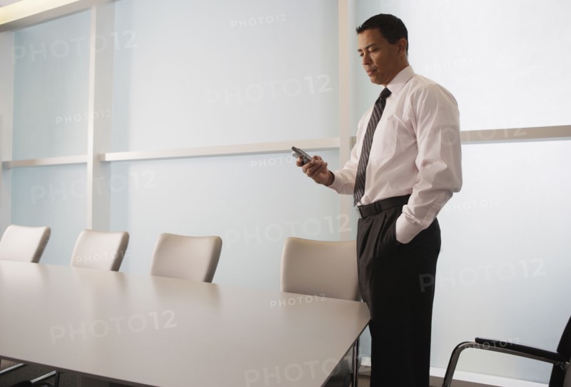Hispanic businessman looking at electronic organizer