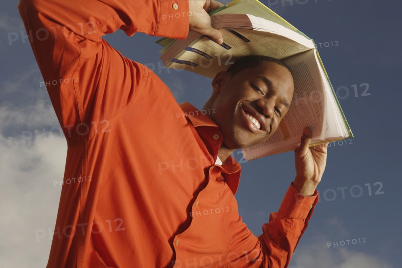 African man holding book over head