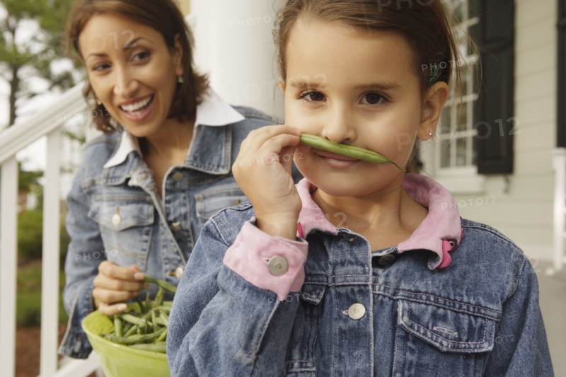 Hispanic mother and daughter with fresh green beans