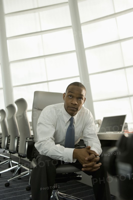 African businessman in conference room looking impatient