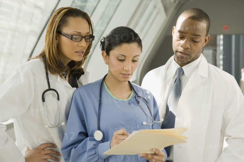 Multi-ethnic doctors and nurse reviewing medical chart