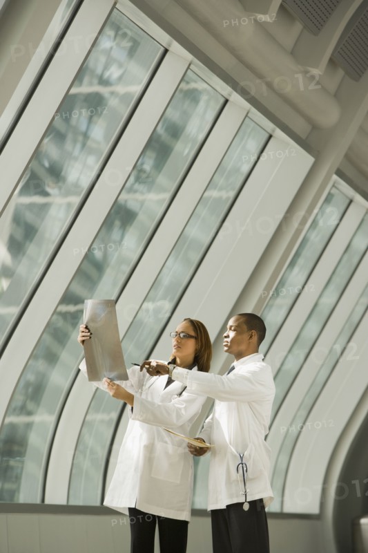 African doctors reviewing x-rays by window