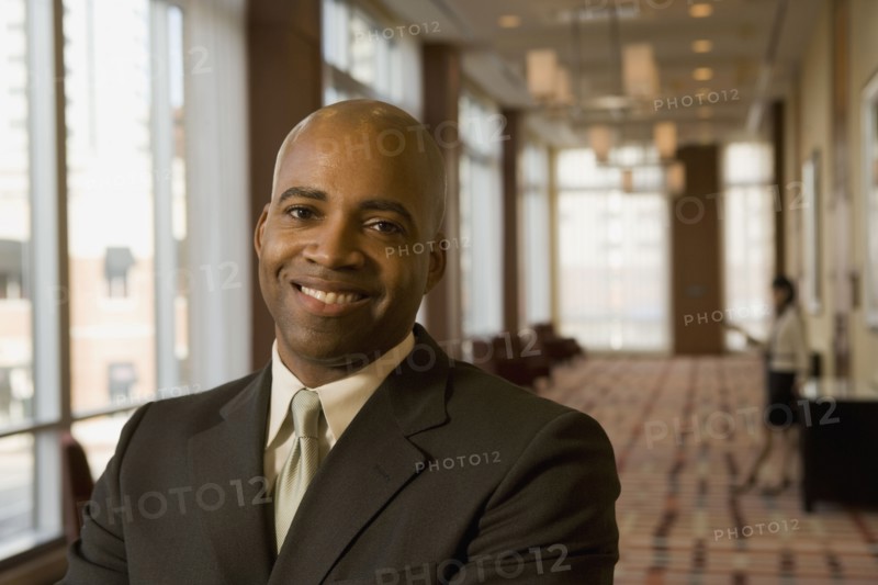 African businessman smiling in hotel corridor
