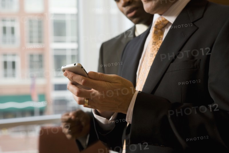 Multi-ethnic business people looking at cell phone