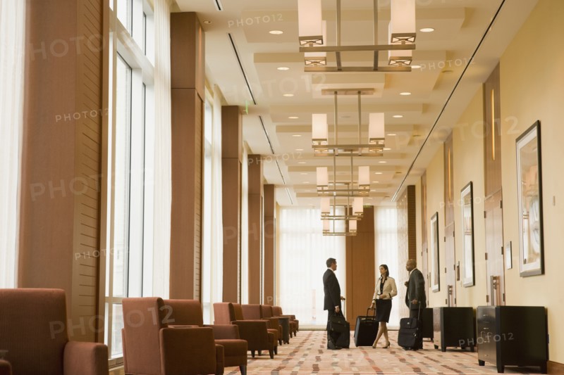 Multi-ethnic business people with suitcases in hotel