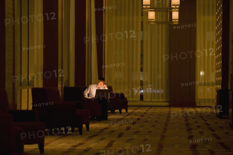 Businessman working on laptop late in lobby
