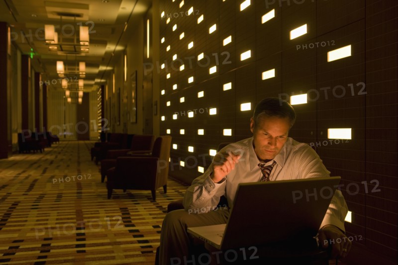 Businessman working on laptop late in lobby