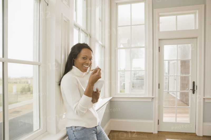 African woman eating in empty room