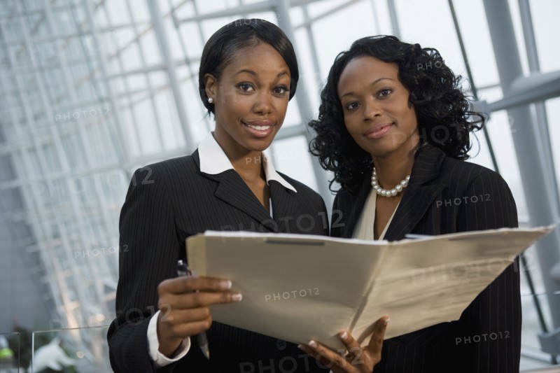 African businesswomen viewing folder