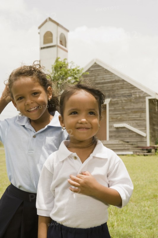 Hispanic sisters standing outside church