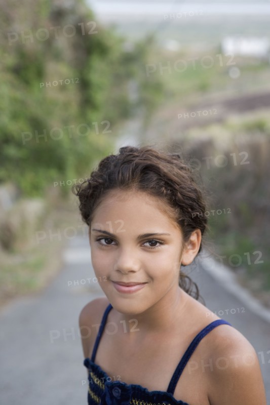Hispanic girl standing in remote roadway