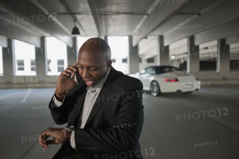African businessman talking on cell phone in parking garage
