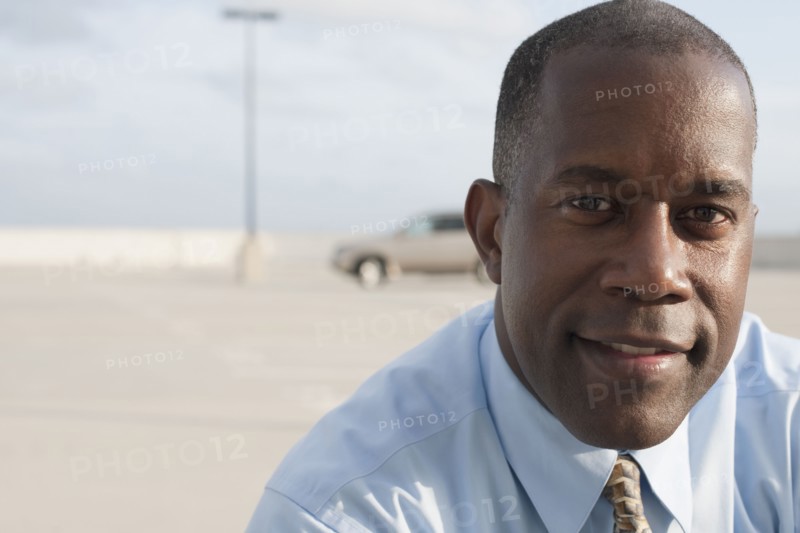 African businessman standing in parking lot