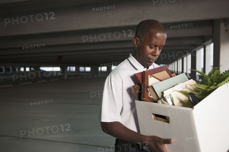 African businessman carrying personal belongings