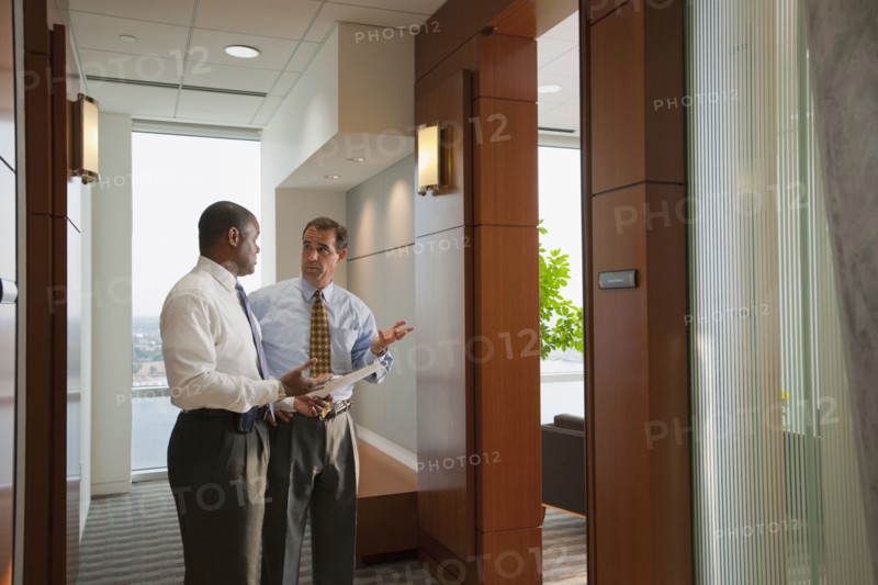 Businessmen talking in office corridor