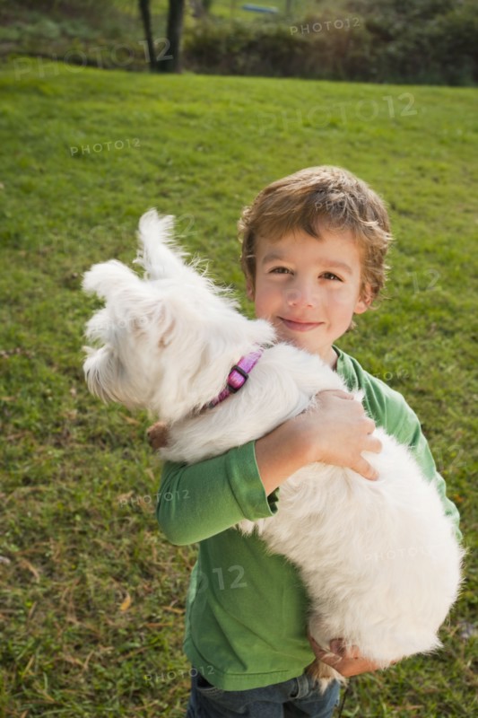 Mixed race boy holding small dog