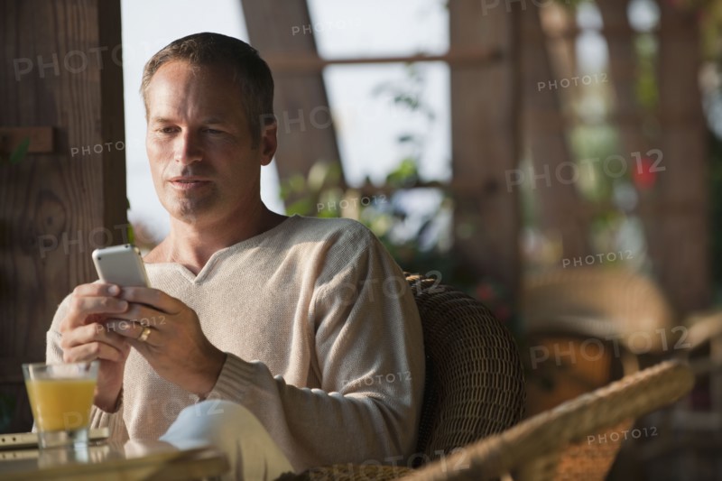Caucasian man text messaging on cell phone in restaurant