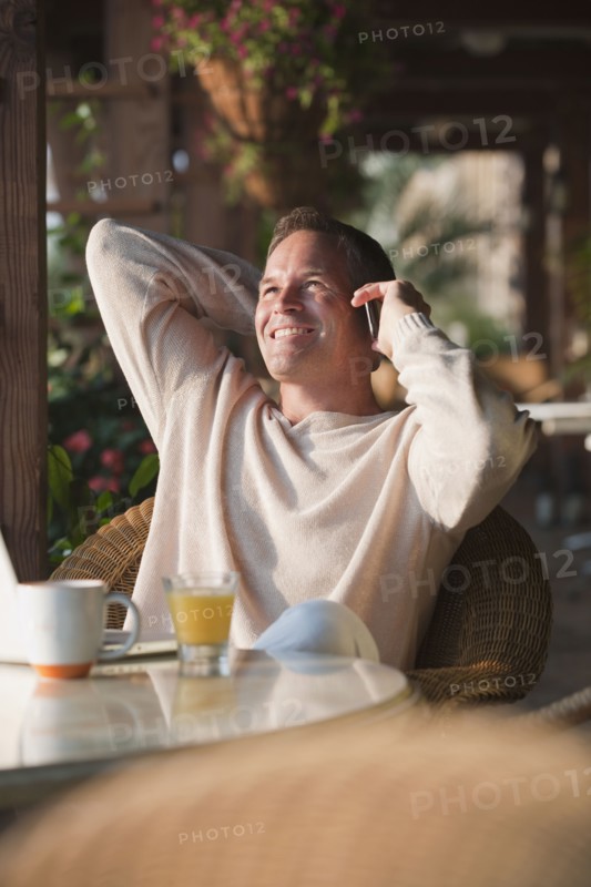 Caucasian man talking on cell phone in restaurant